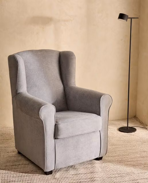 Sillón orejero Bay de El Corte Inglés tapizado en gris con estructura de madera sólida