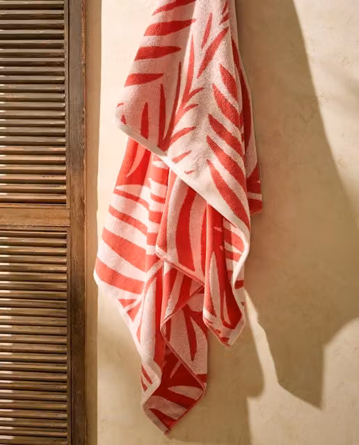 Toalla de playa Branch de El Corte Inglés con diseño floral en colores coral y rojo para adultos