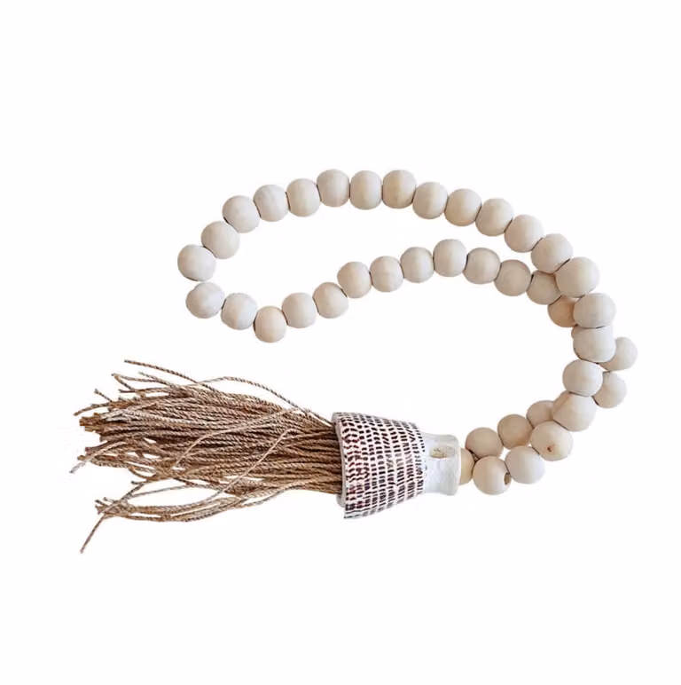 Guirnalda colgante boho de My Bliss Home con pompones, conchas y madera en colores blanco y beige
