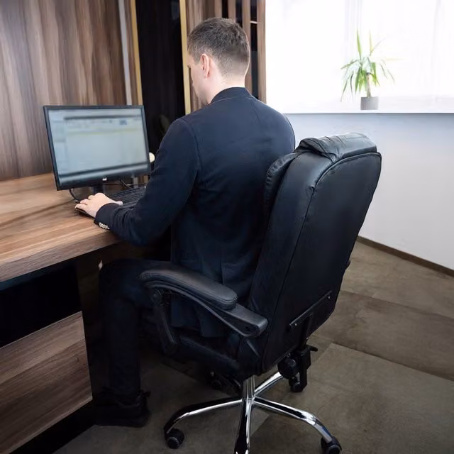 Sillón de oficina ejecutivo Malatec en color negro con acabado en piel sintética, diseño moderno giratorio con reposapiés y ruedas para tu hogar u oficina