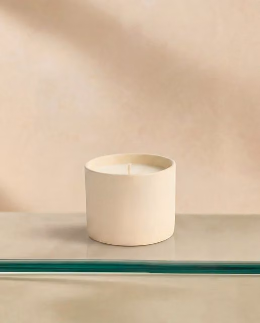 Vela aromática orgánica Cuero y Azafrán de El Corte Inglés en vaso de cerámica beige y marrón con aroma amaderado
