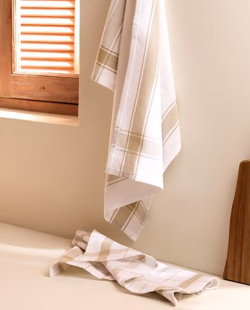 Set de 2 paños de sarga de algodón Nova de El Corte Inglés con diseño de cuadros en beige y blanco