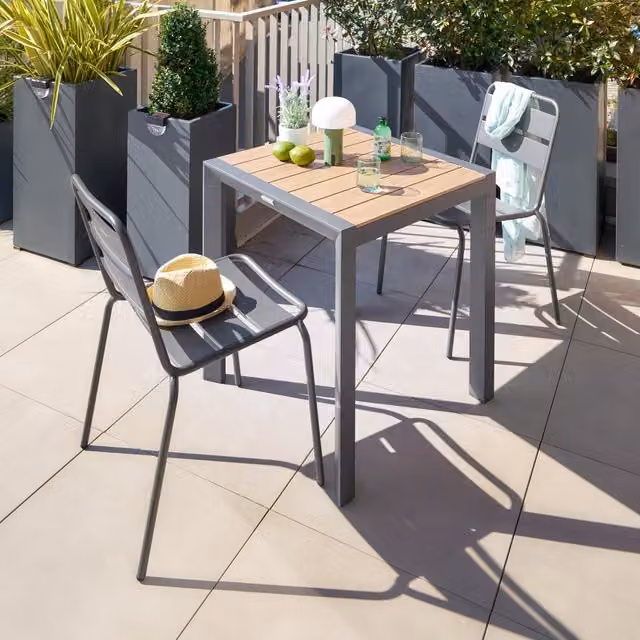 Mesa de jardín Hespéride Evasion de aluminio con efecto madera color miel y grafito para 2 personas