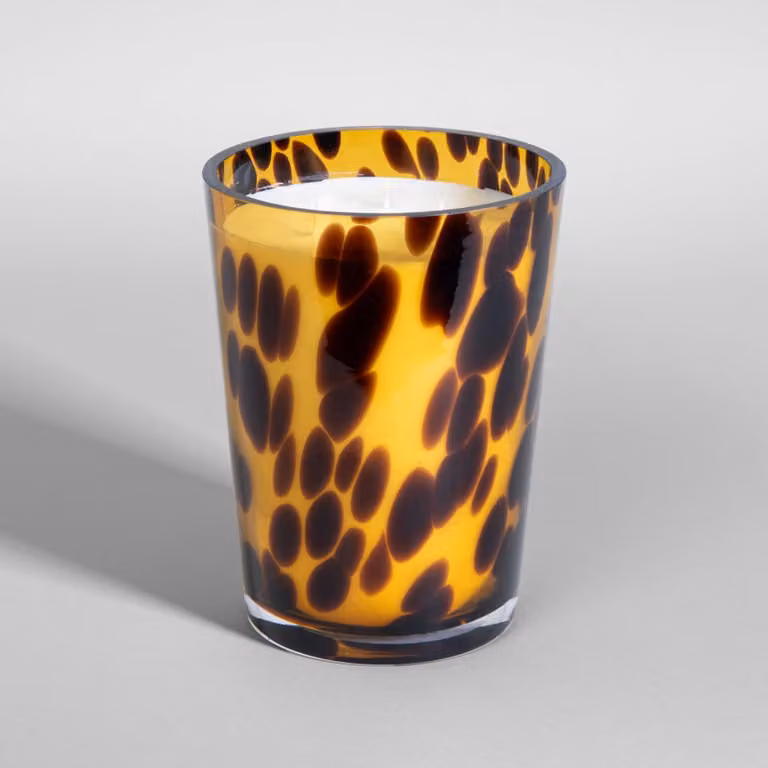 Vela perfumada de Maisons du Monde con aroma madera especiada en vidrio negro y marrón de estilo étnico