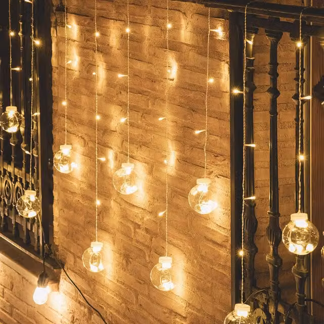 Cortina de bolas colgantes LED Ledkia en color blanco, transparente y luz blanco cálido, fabricada en PVC