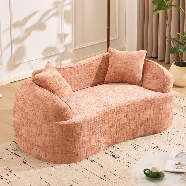 Sofá de dos plazas KELLANY con diseño curvo y redondeado en color rosa o beige, incluye 2 cojines y es ideal para tu salón, dormitorio o despacho.