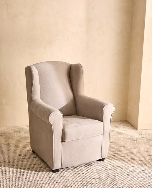 Sillón orejero clásico Bay de El Corte Inglés tapizado en tejido beige con estructura de madera maciza